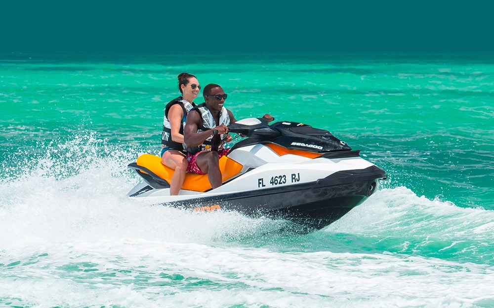 a man riding on the back of a boat in the water